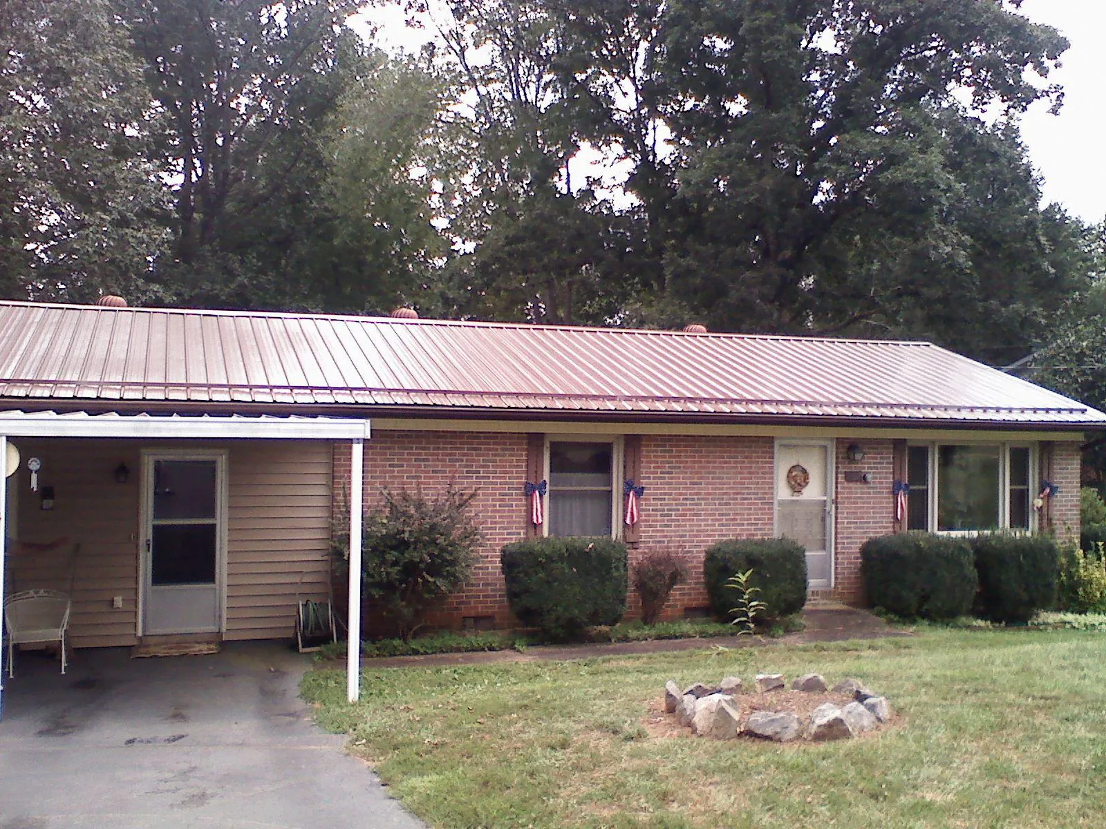 Bronze metal roof and carport on a brick ranch home — Roof Repair work by our crew in Demorest
